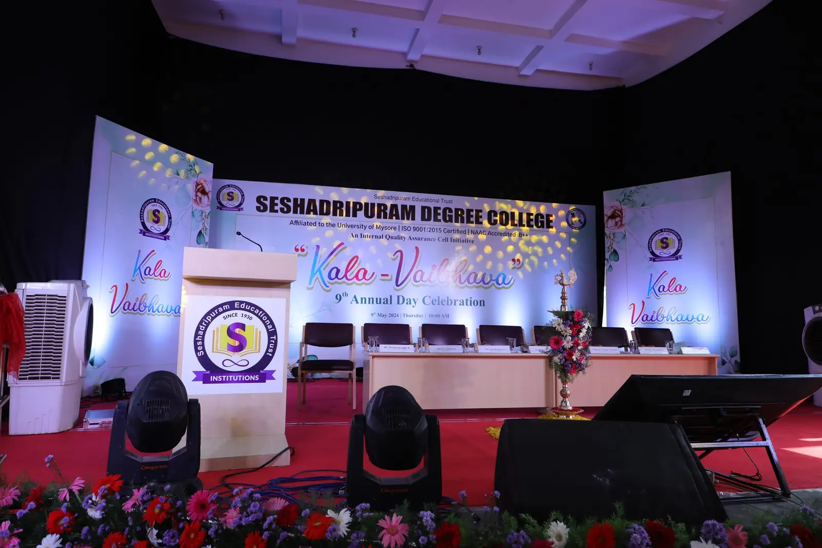 College annual day stage with moving-head lights and printed backdrop